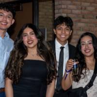 Five grads smile at Toast holding champagne flutes